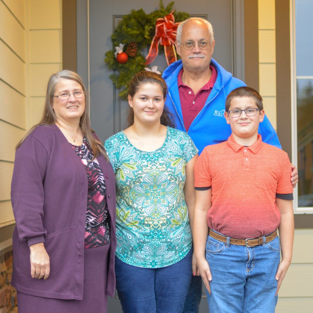 Smiling family posing by the door