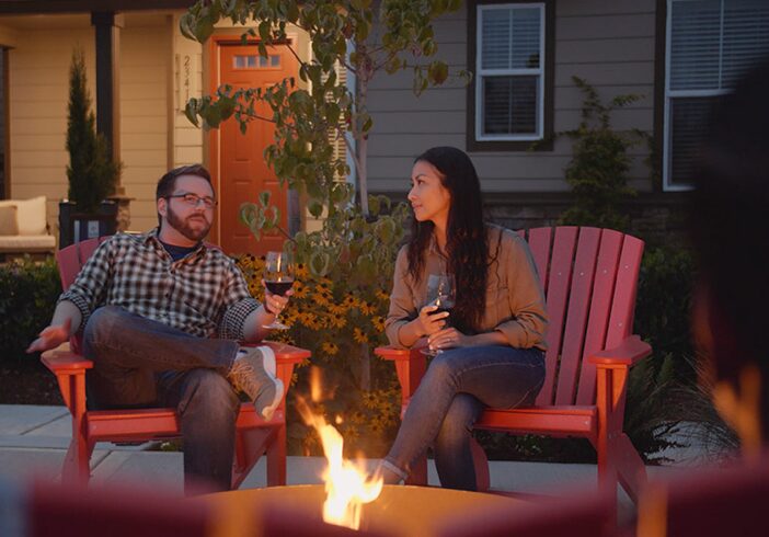 Couple enjoying wine by a firepit
